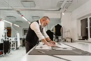 Kleermaker aan het werk in zijn atelier
