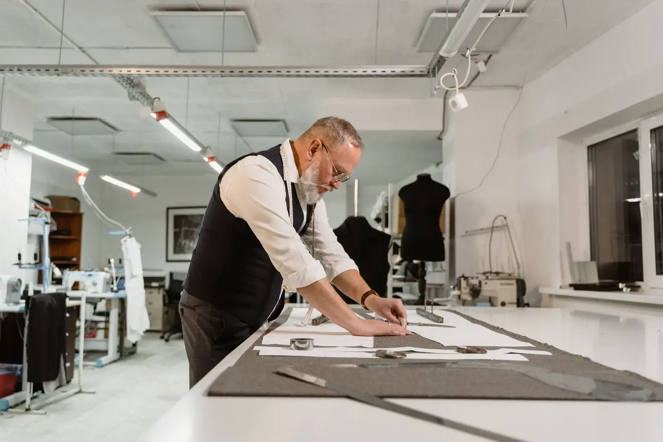 Kleermaker aan het werk in zijn atelier